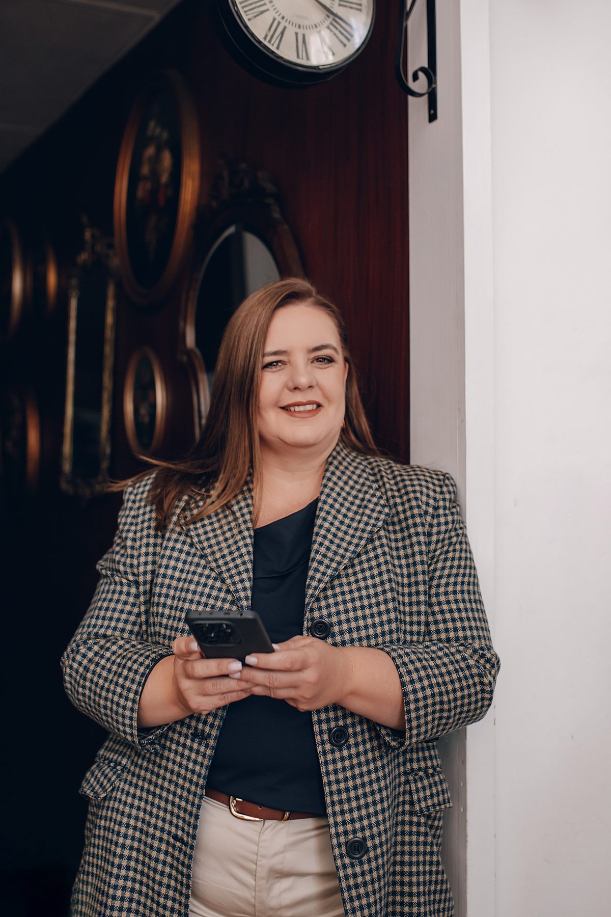 Paula Dias Aguiar de blazer, com um telemóvel na mão